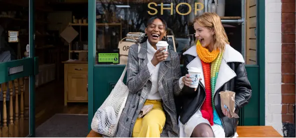 Two women drinking coffee and laughing